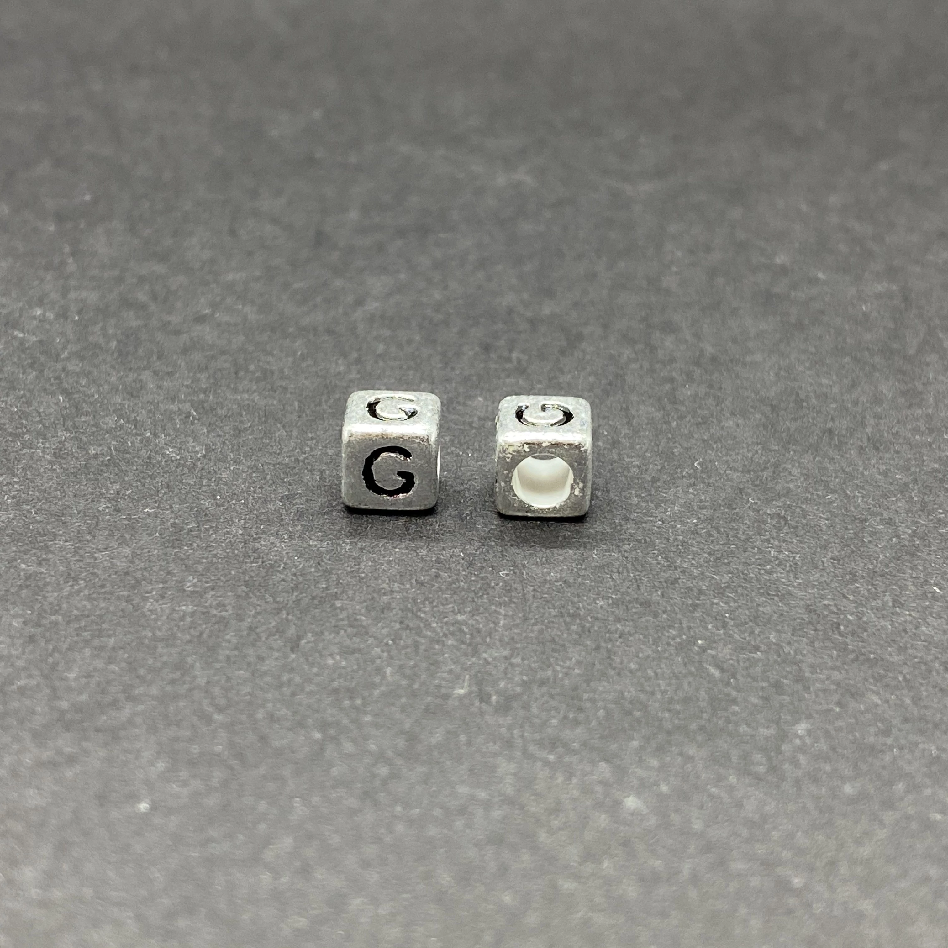 Műanyag ezüst színű g betűgyöngy (6mm)
