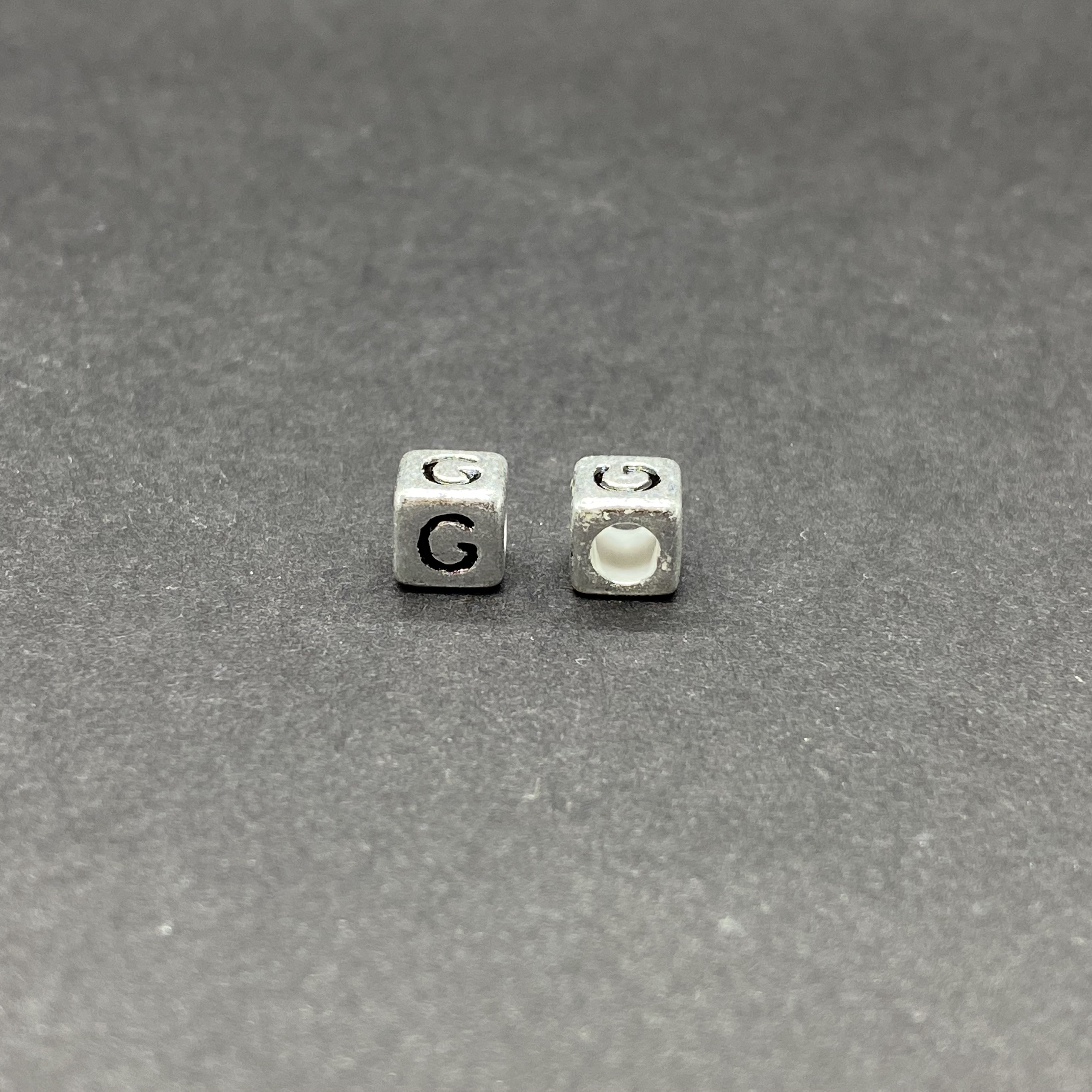 Műanyag ezüst színű g betűgyöngy (6mm)