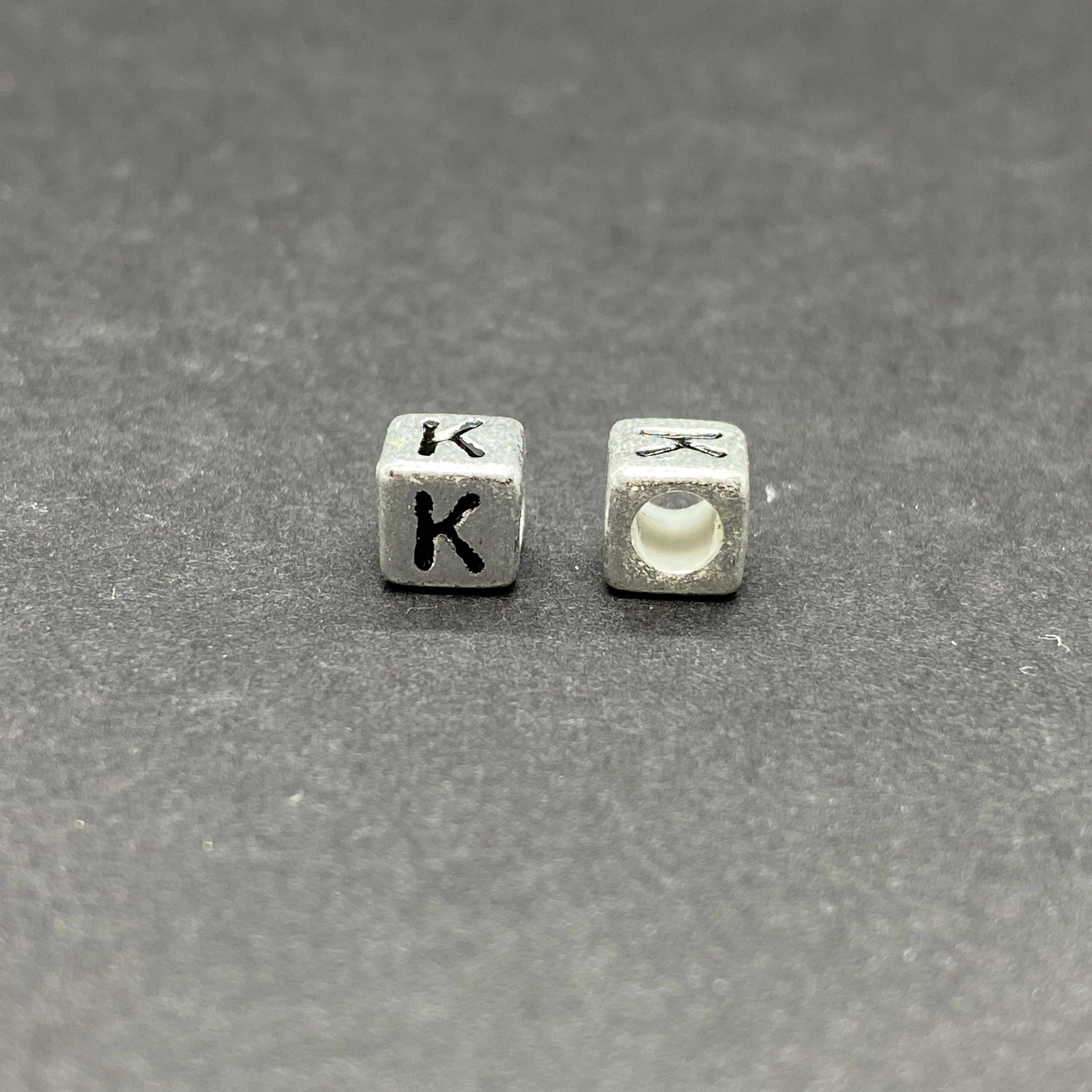 Műanyag ezüst színű k betűgyöngy (6mm)
