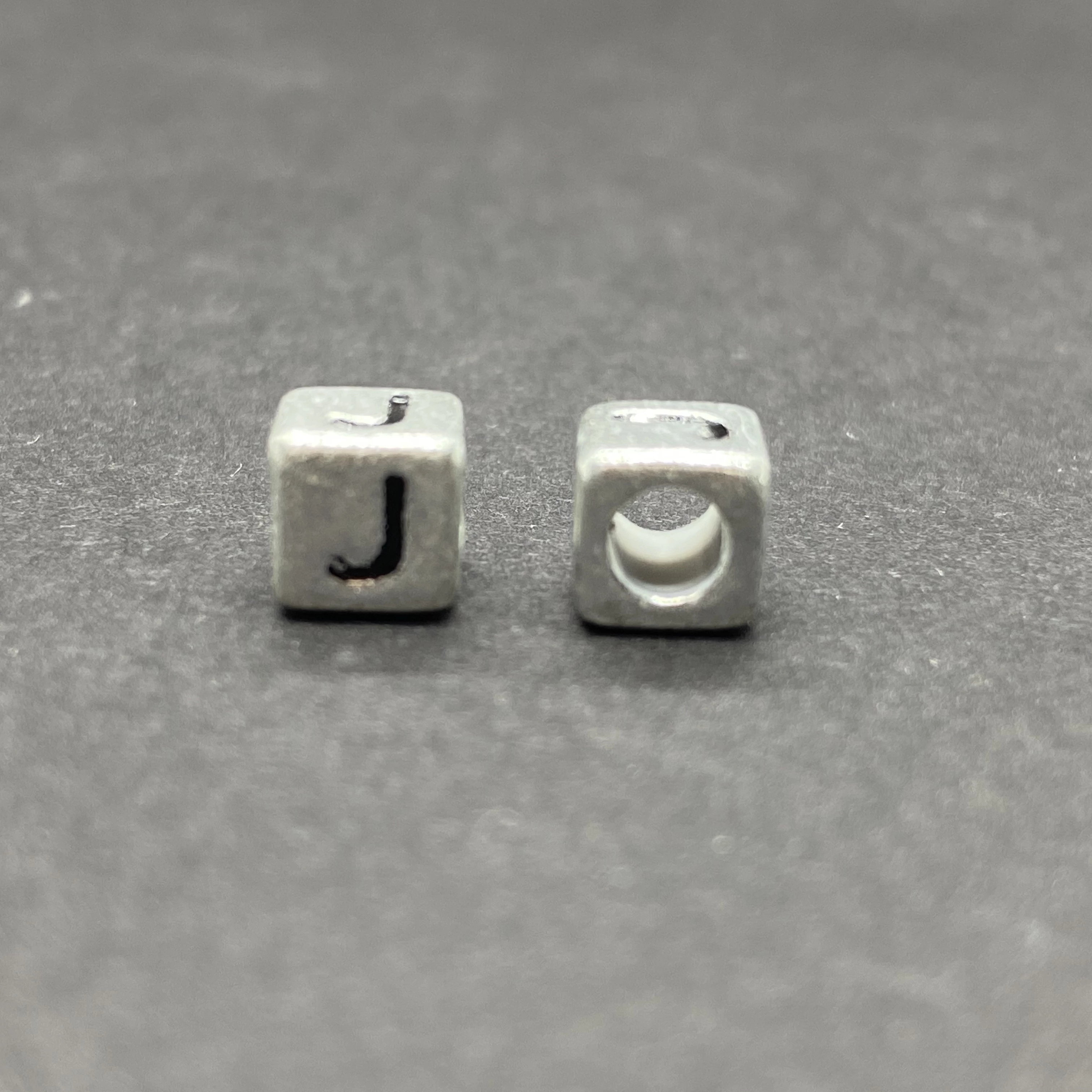 Műanyag ezüst színű j betűgyöngy (6mm)