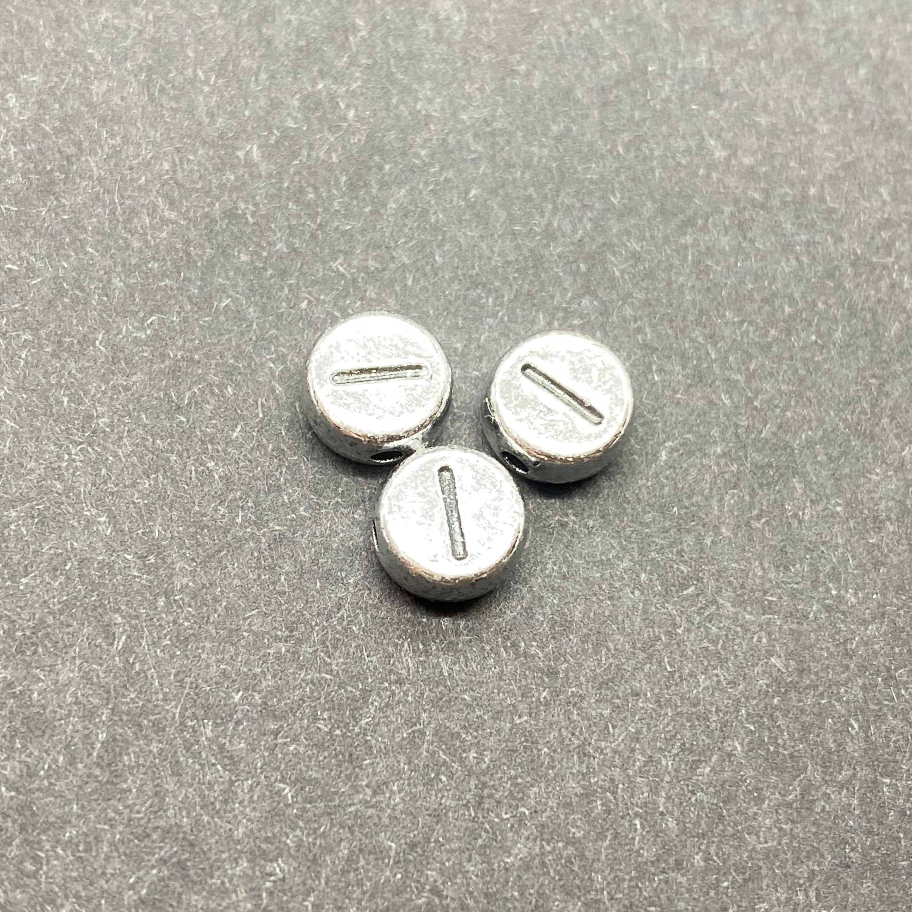 Műanyag ezüst színű kör i betűgyöngy (7mm)