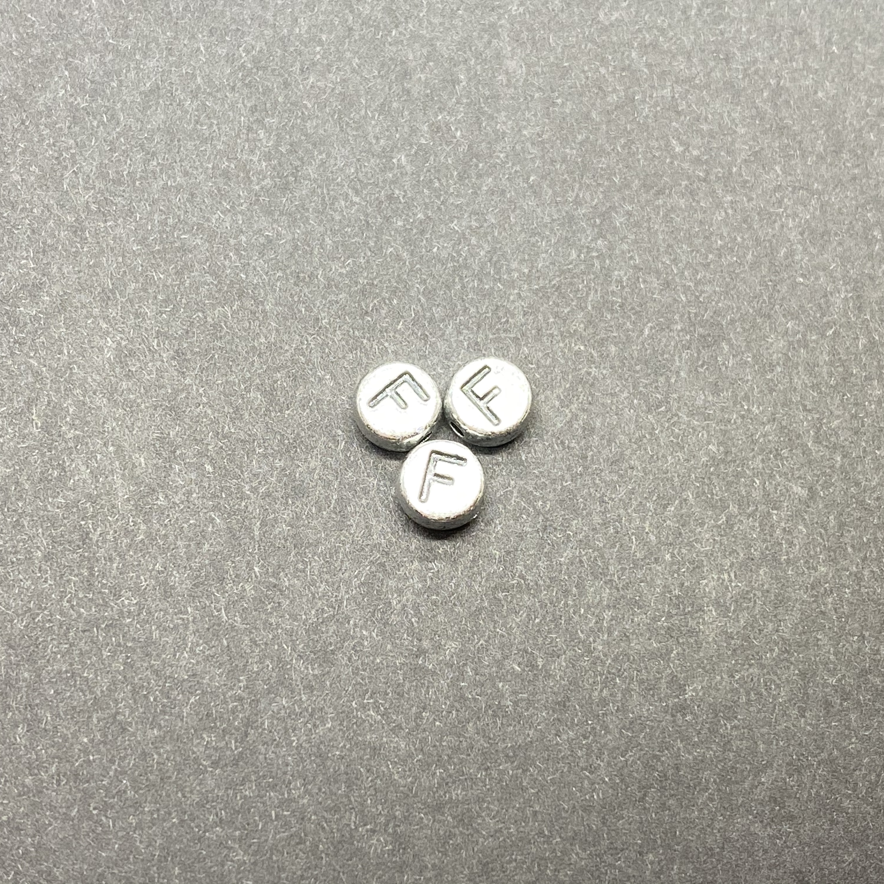 Műanyag ezüst színű kör f betűgyöngy (7mm)