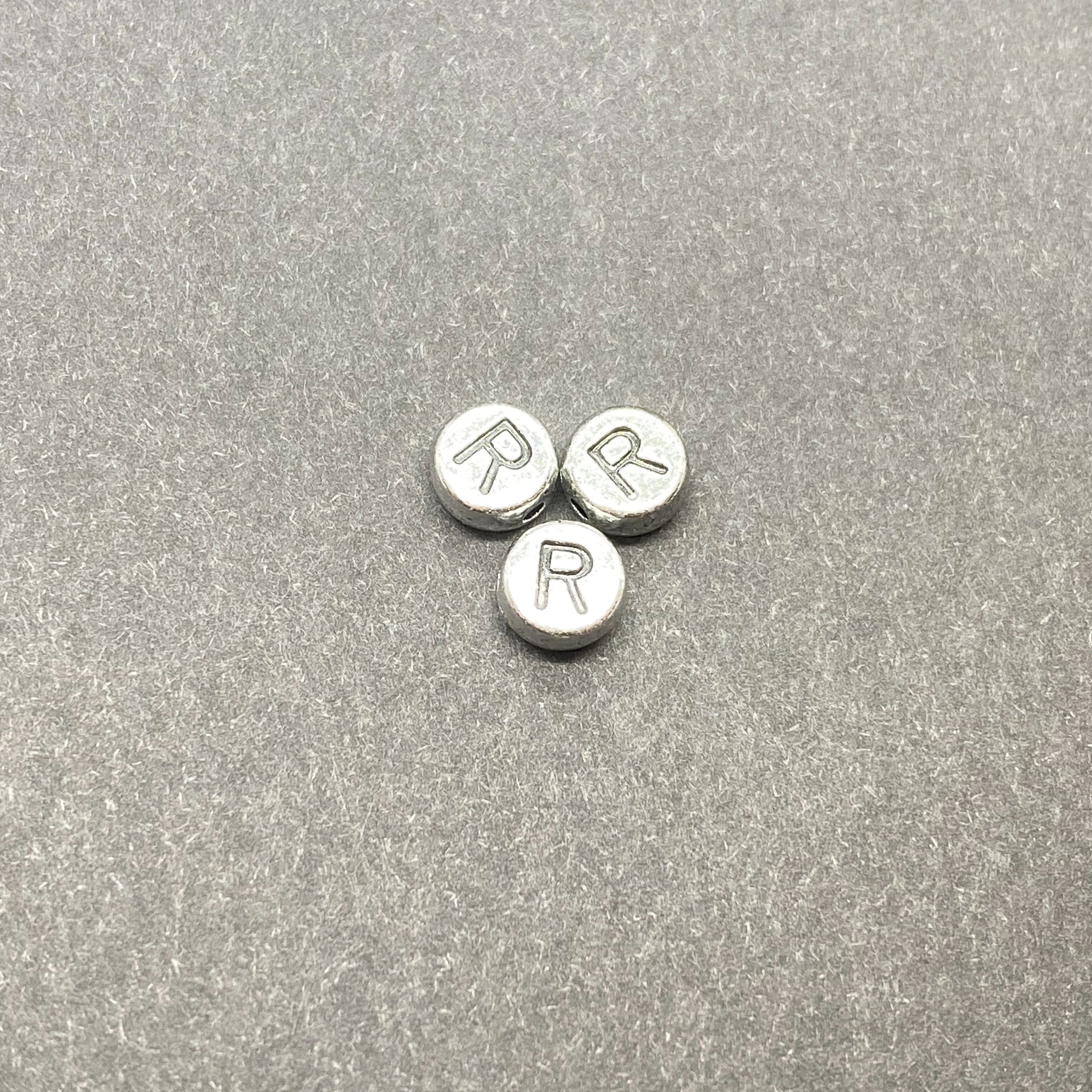 Műanyag ezüst színű kör r betűgyöngy (7mm)
