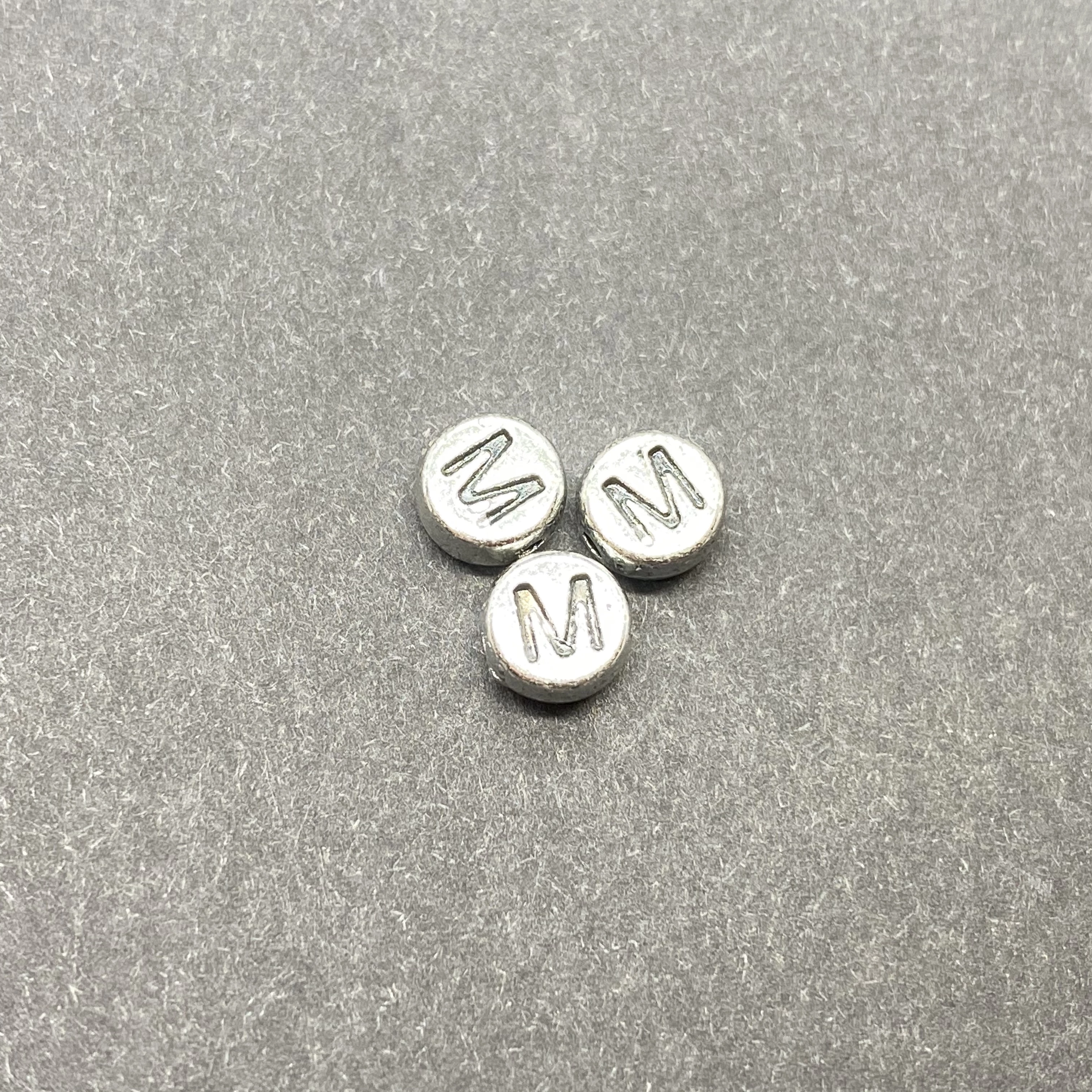 Műanyag ezüst színű kör m betűgyöngy (7mm)