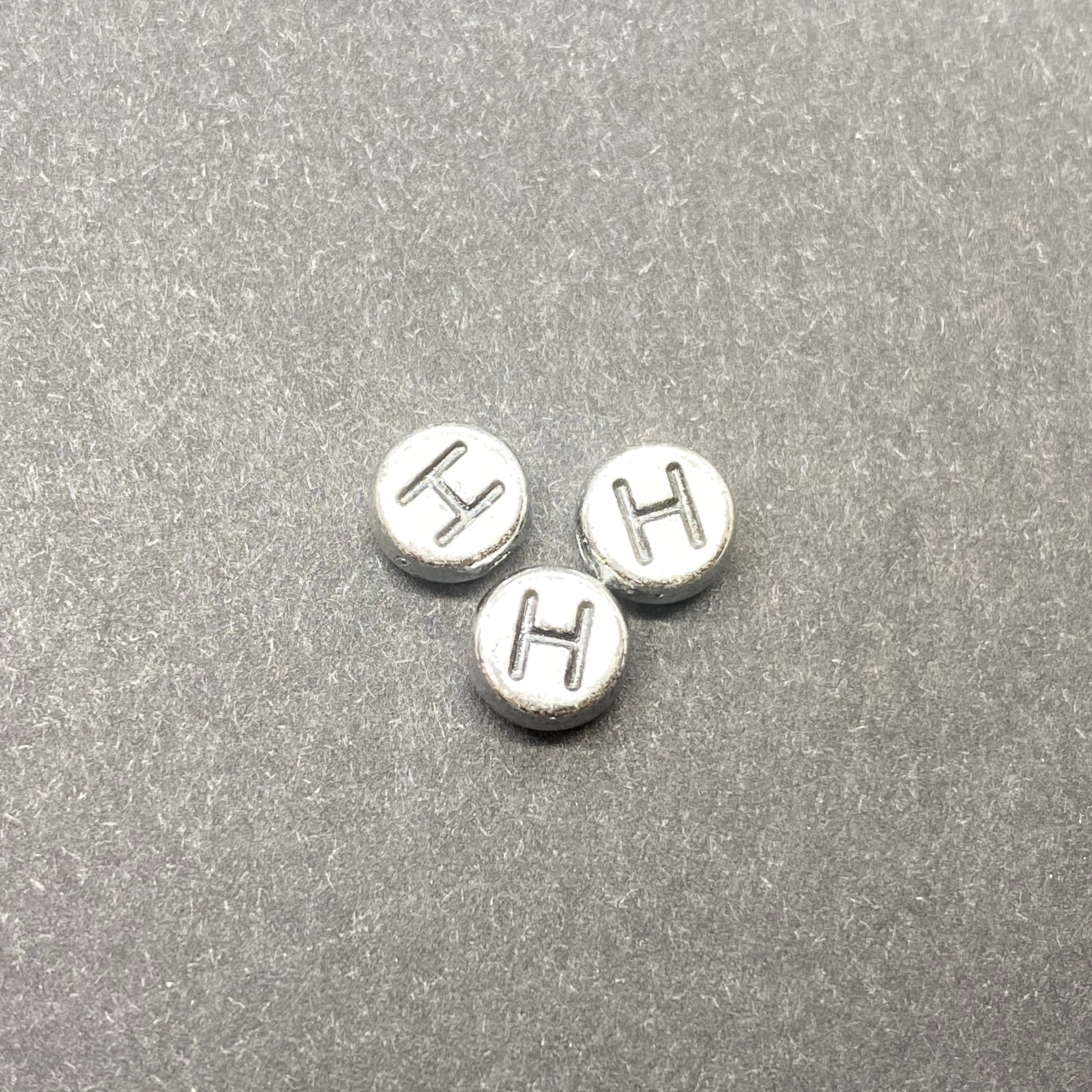 Műanyag ezüst színű kör h betűgyöngy (7mm)