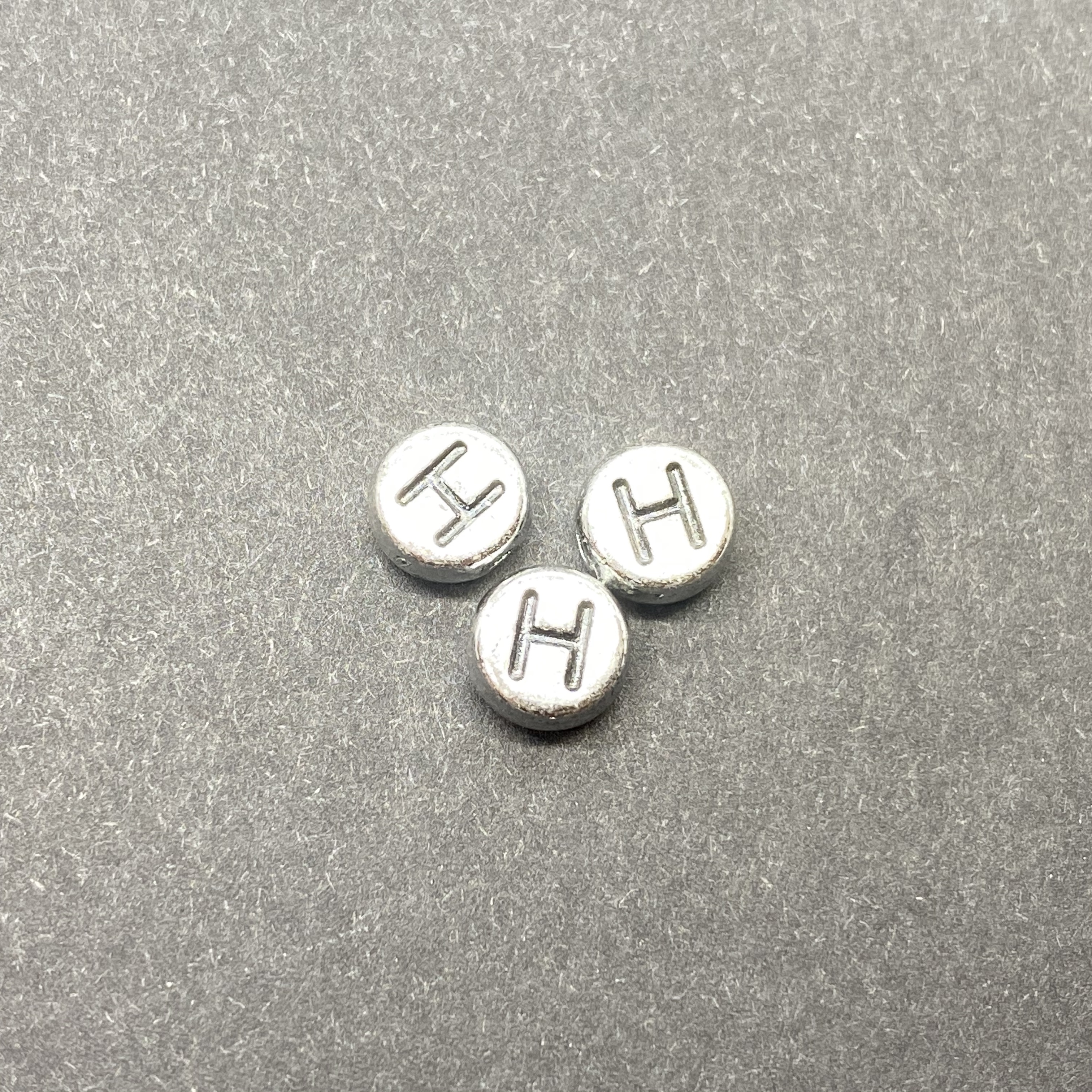 Műanyag ezüst színű kör h betűgyöngy (7mm)