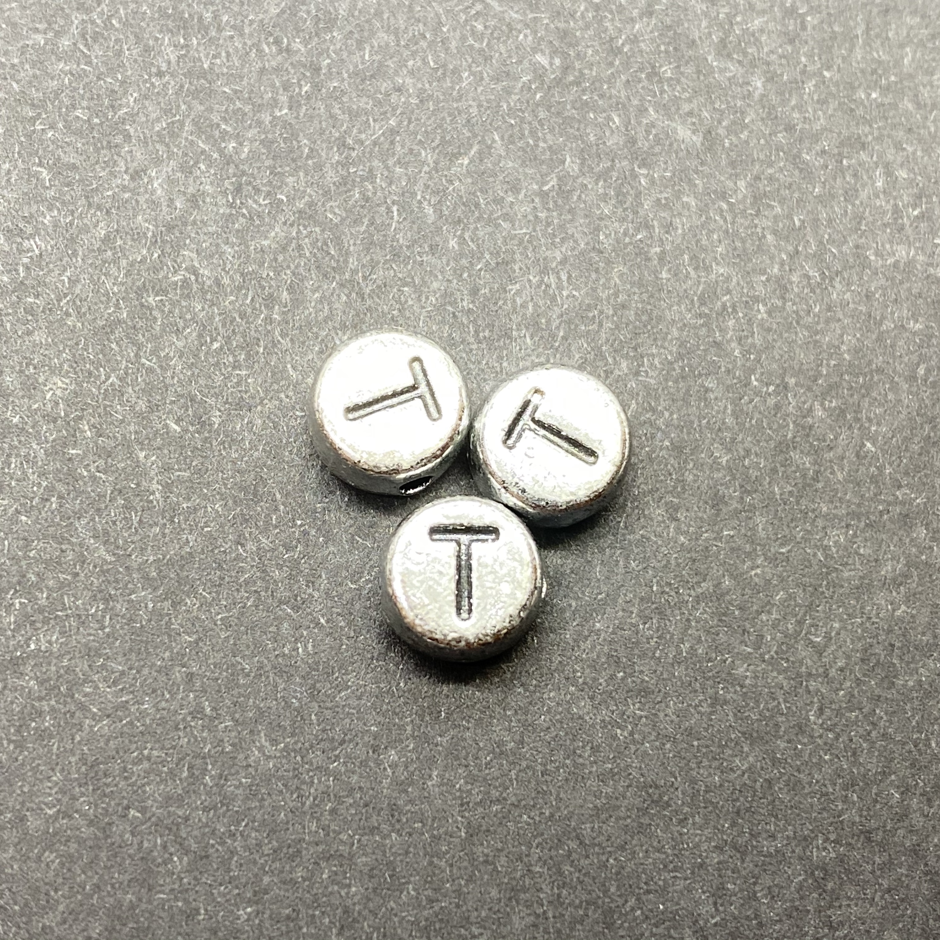 Műanyag ezüst színű kör t betűgyöngy (7mm)