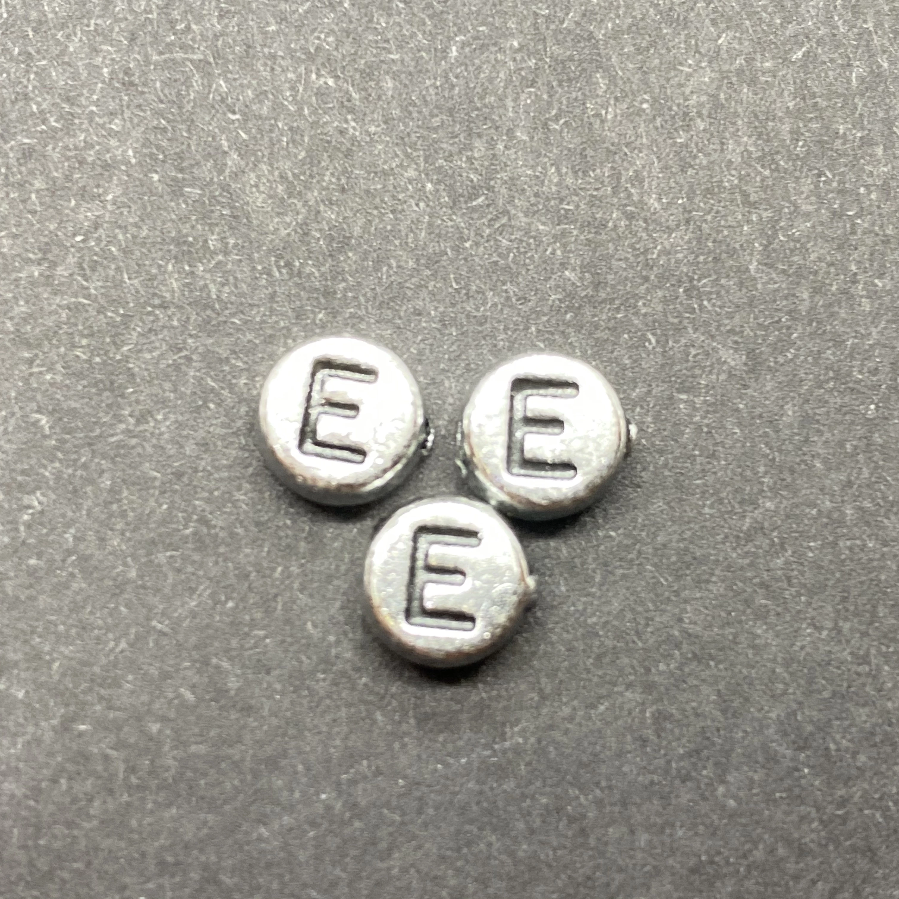 Műanyag ezüst színű kör e betűgyöngy (7mm)