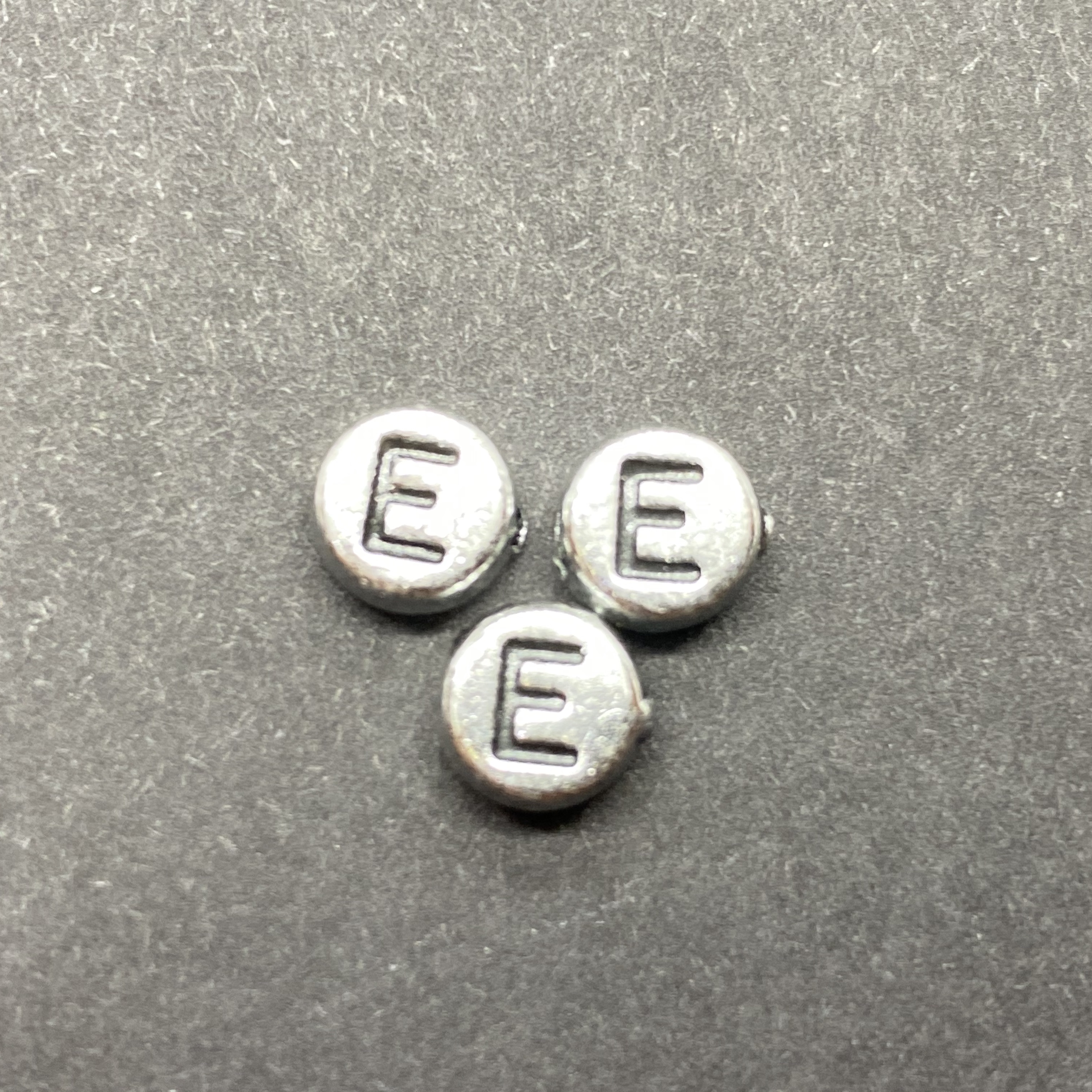 Műanyag ezüst színű kör e betűgyöngy (7mm)