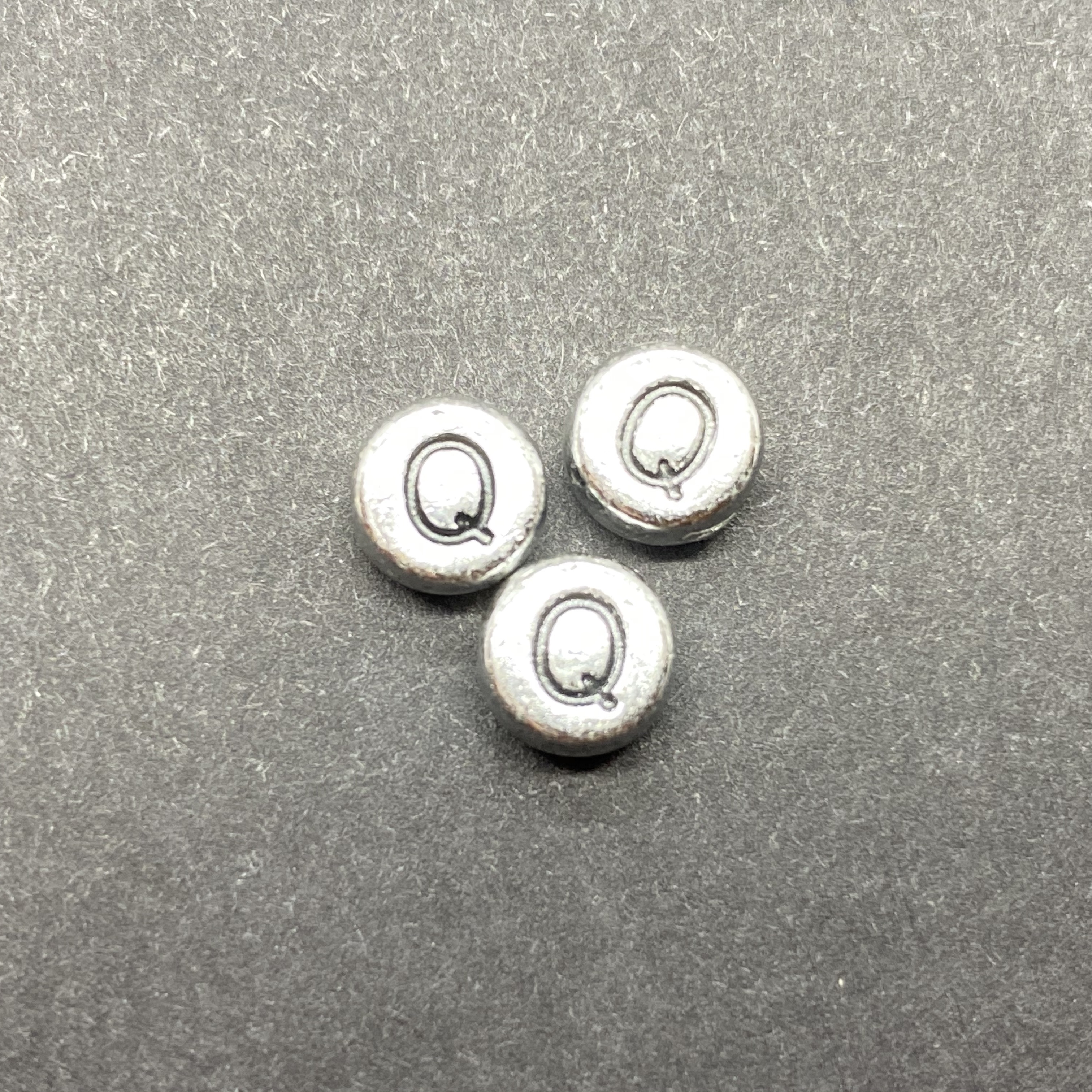 Műanyag ezüst színű kör q betűgyöngy (7mm)