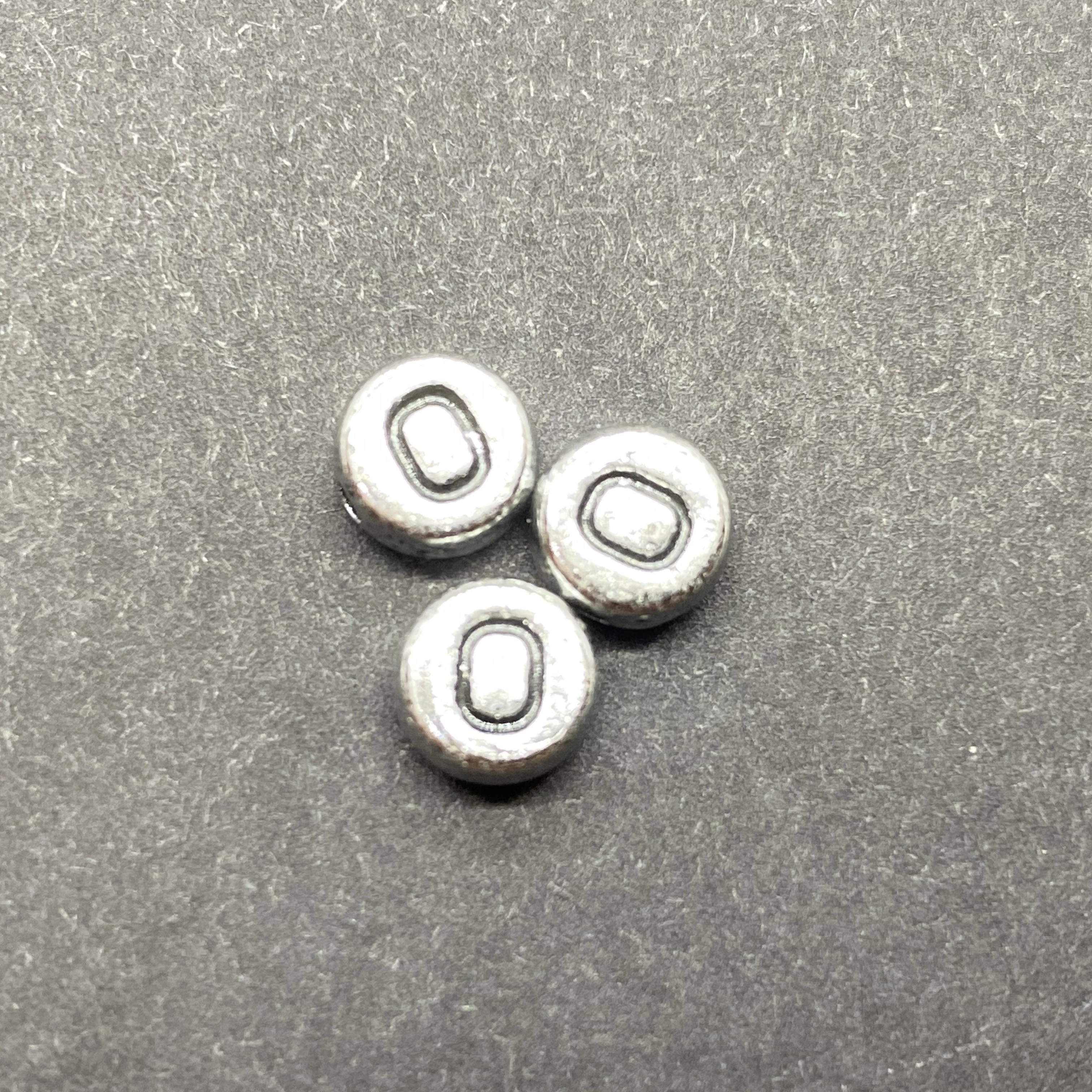 Műanyag ezüst színű kör o betűgyöngy (7mm)