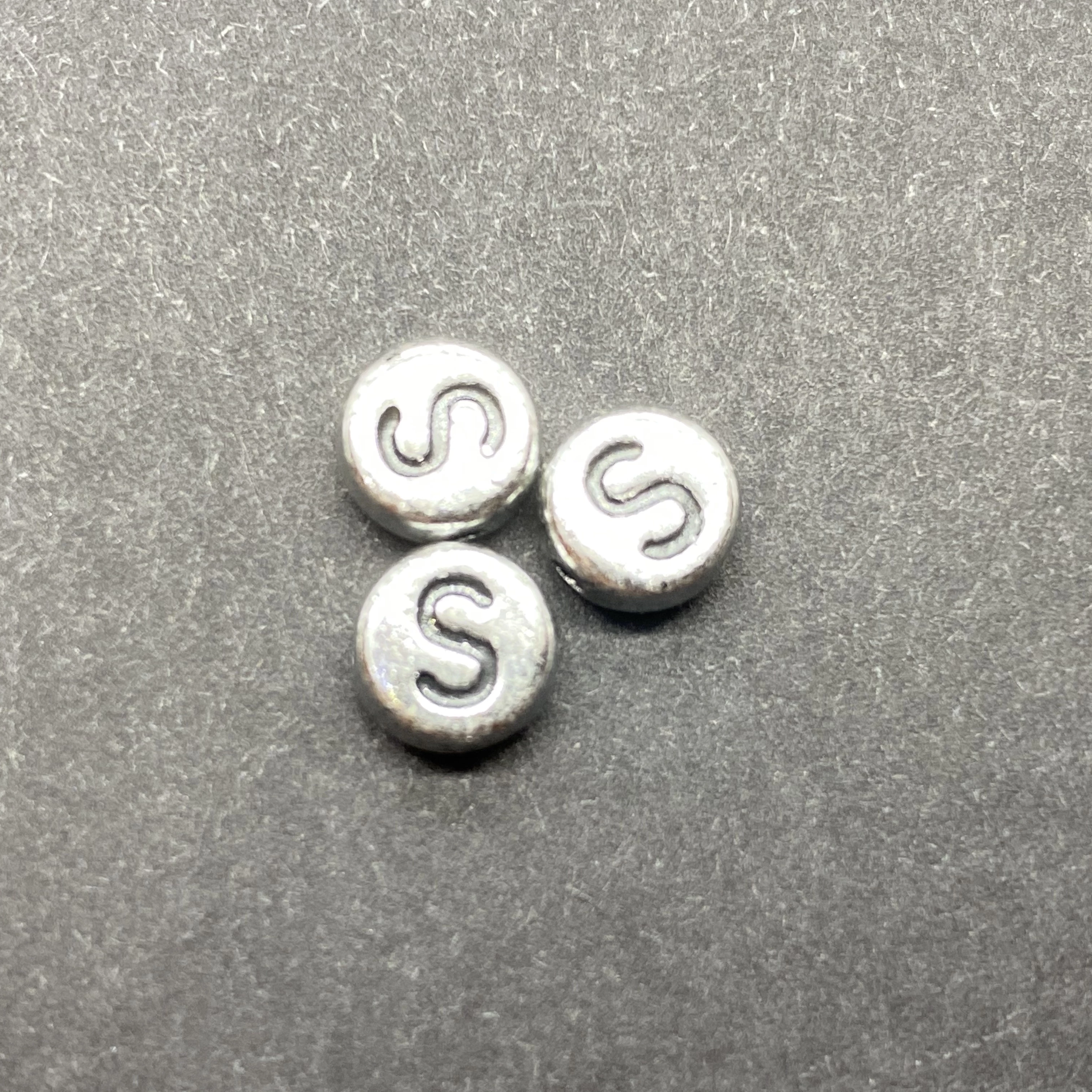 Műanyag ezüst színű kör s betűgyöngy (7mm)