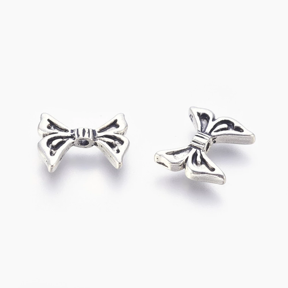 Antikolt ezüst színű masni köztes (12x14mm)